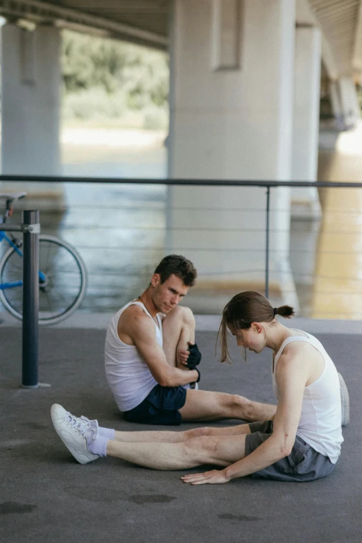 a man and a woman sitting on the ground, by Jane Kelly, pexels contest winner, athletic muscle tone, melbourne, hydration, thin young male