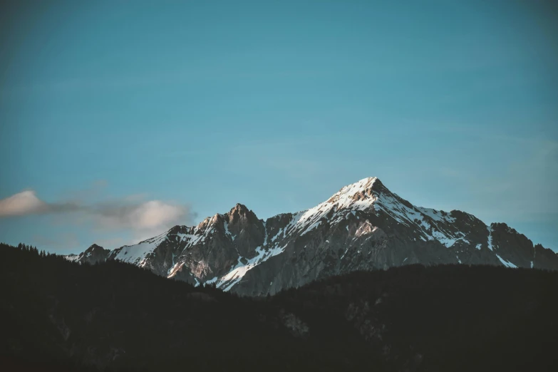 a mountain covered in snow under a blue sky, a picture, unsplash contest winner, minimalism, early evening, brown, towering over your view, craggy