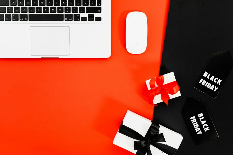 a laptop computer sitting on top of a red desk, by Julia Pishtar, pexels contest winner, giving gifts to people, black and orange colour palette, flat lay, red white and black