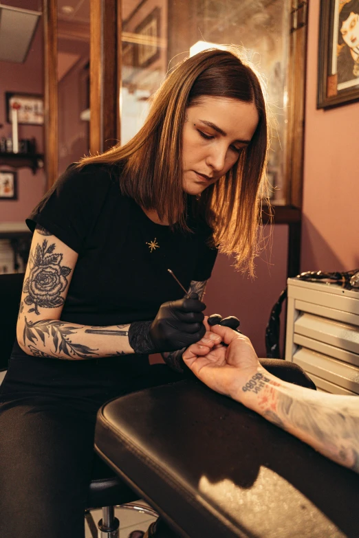 a woman getting a tattoo on another woman's arm, a tattoo, by Morgan Russell, trending on pexels, hyperrealism, sailor jerry tattoo flash, hands on counter, sharp tip, makeup