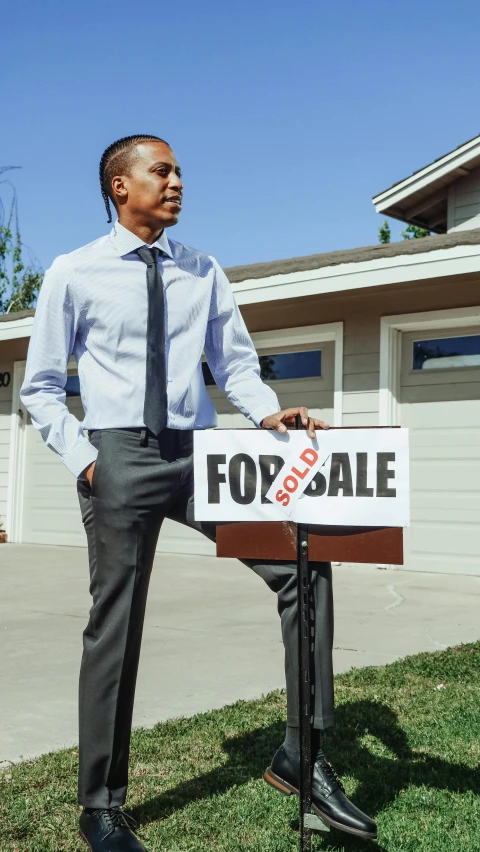 a man standing in front of a house holding a for sale sign, unsplash, photorealism, dressed in a suit, vehicle, square, production still