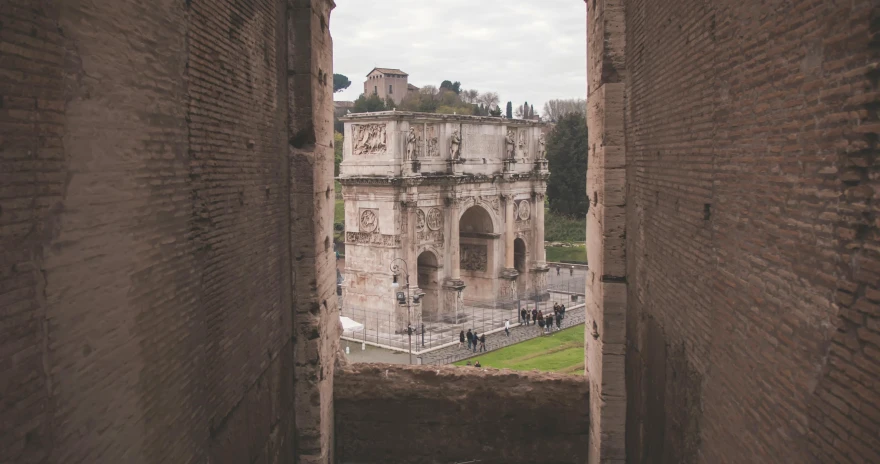 a view of a building through a window, pexels contest winner, neoclassicism, inside the roman colliseum, huge gate, brown, video