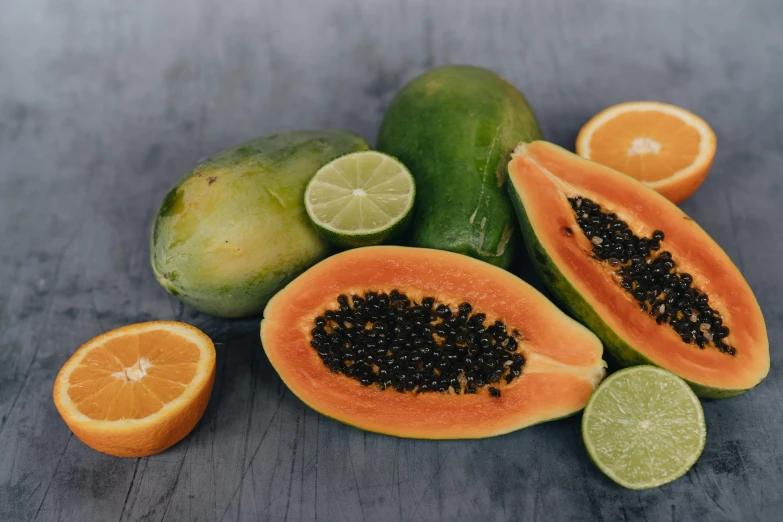 a bunch of fruit sitting on top of a table, orange and black, tropical undertones, seeds, wearing a melon