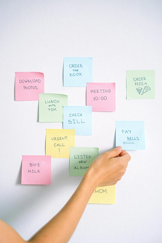 a woman standing in front of a whiteboard covered in post it notes, diary on her hand, square sticker, 2019 trending photo, detailed product image