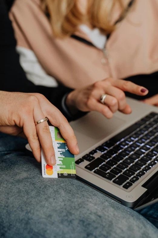 a woman sitting on a couch using a laptop computer, a screenshot, trending on pexels, renaissance, holding an ace card, coworkers, brand colours are green and blue, lesbians