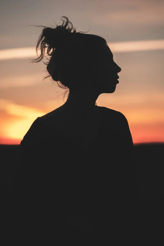 a woman standing in front of a sunset, profile image