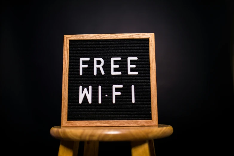 a free wifi sign sitting on top of a wooden stool, a portrait, pexels, 1 6 x 1 6, black, photos, 10k