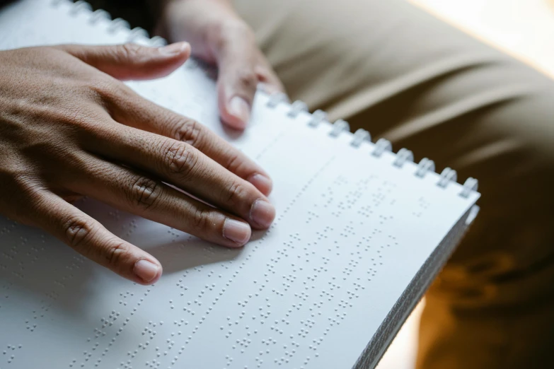 a close up of a person holding a book, a stipple, hurufiyya, with index finger, varying dots, holding notebook, grey