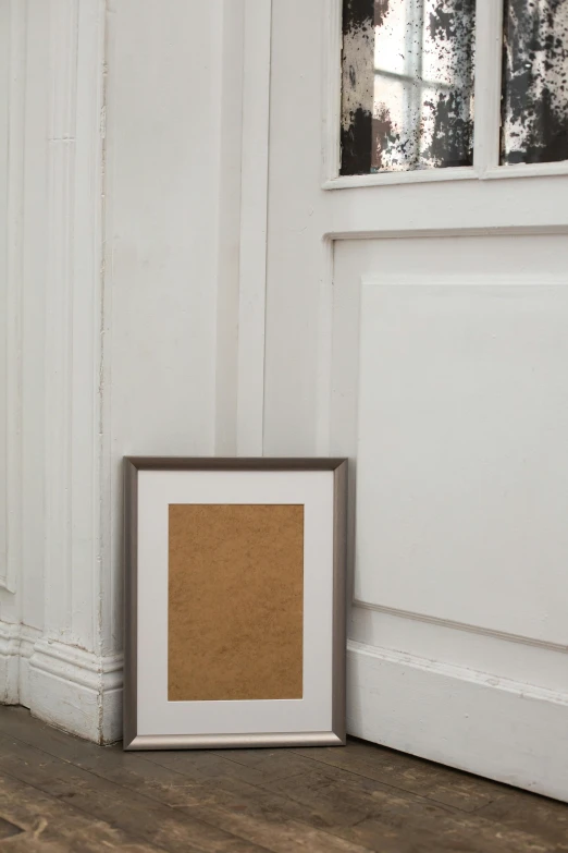 a cat sitting on the floor next to a picture frame, inspired by Agnes Martin, unsplash, tall door, brown paper, detailed product shot, background image