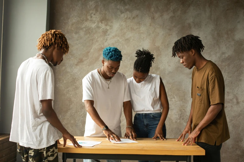 a group of people standing around a wooden table, pexels contest winner, black arts movement, college students, blue print, afro tech, character sheets on table