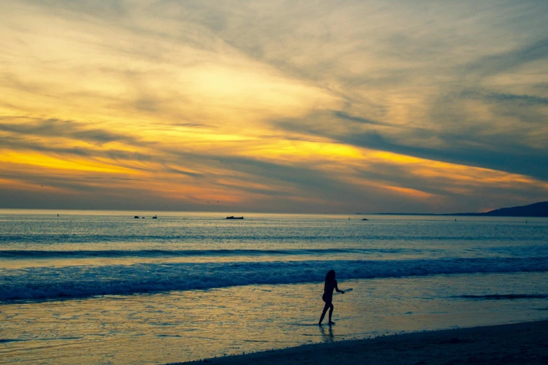 a person standing on top of a beach next to the ocean, by Liza Donnelly, pexels contest winner, sunsetting color, walking down, oceanside, floating away