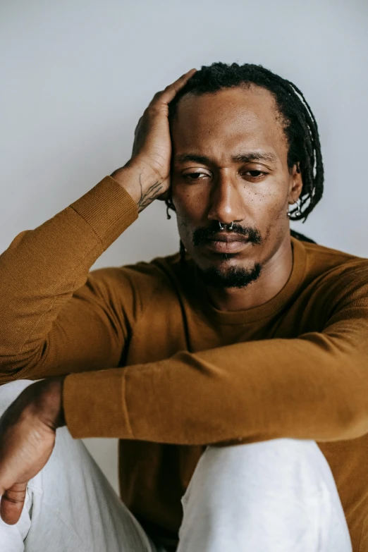 a man with dreadlocks sitting on the floor, by Winona Nelson, trending on pexels, romanticism, he is wearing a brown sweater, portrait of snoop dogg, depressed dramatic bicep pose, kara walker james jean