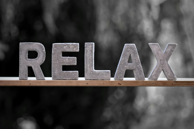 a black and white photo of the word relax on a bench, pexels, on grey background, sitting on a store shelf, various posed, made of glazed