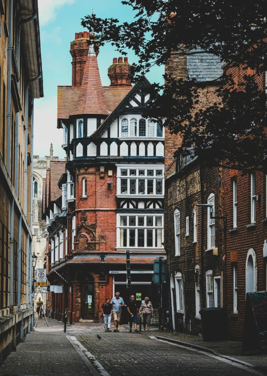 a couple of people walking down a street next to tall buildings, by IAN SPRIGGS, pexels contest winner, renaissance, timbered house with bricks, hull, gothic revival, panoramic