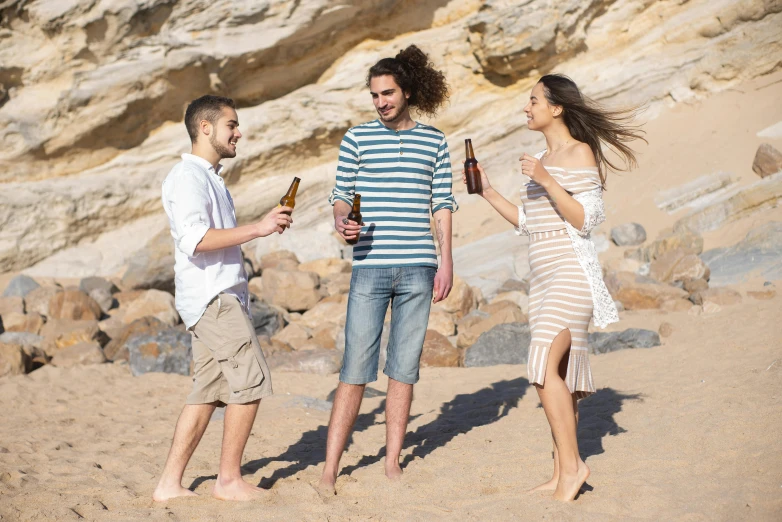 a group of people standing on top of a sandy beach, holding a beer, profile image, playing at the beach, modelling