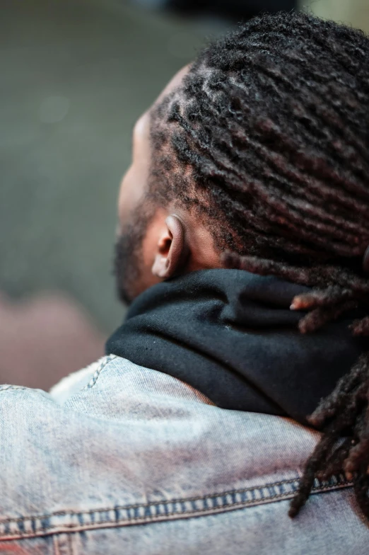 a man with dreadlocks using a cell phone, trending on pexels, man wearing a closed cowl, arm around her neck, black, facing away