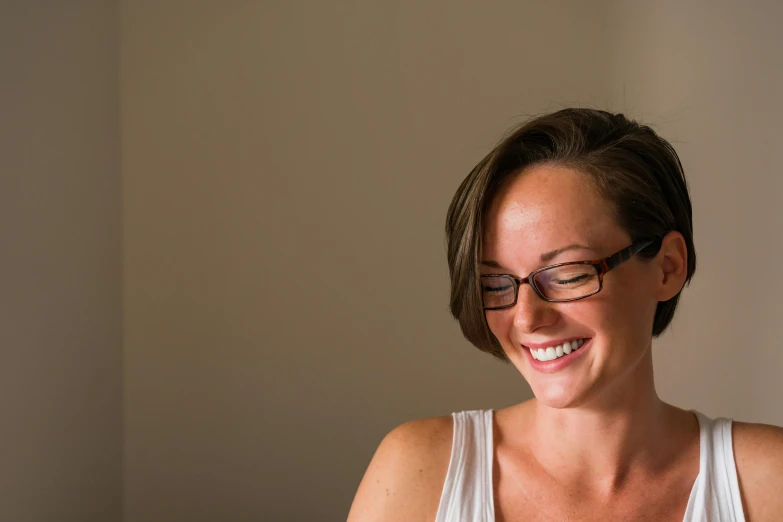 a woman sitting at a table with a plate of food, wearing black frame glasses, lachlan bailey, head bent back in laughter, soft lighting and focus