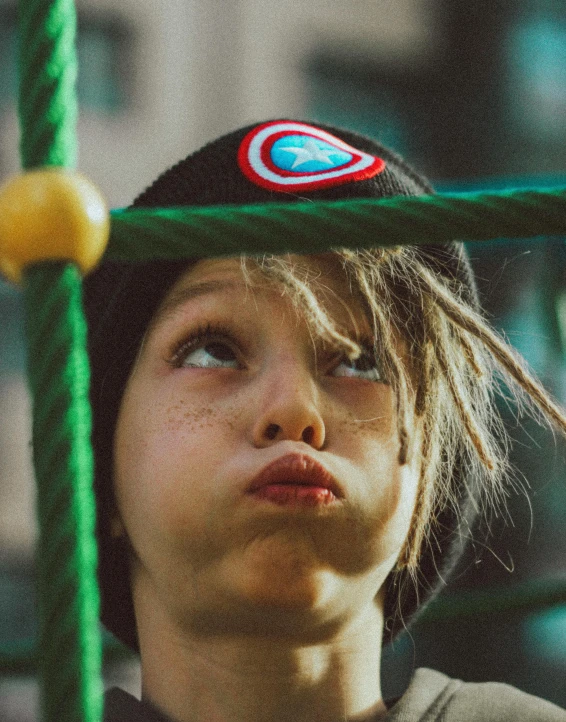 a close up of a person wearing a hat, an album cover, inspired by Elsa Bleda, trending on pexels, incoherents, happy kid, swings, looking scared, superhero