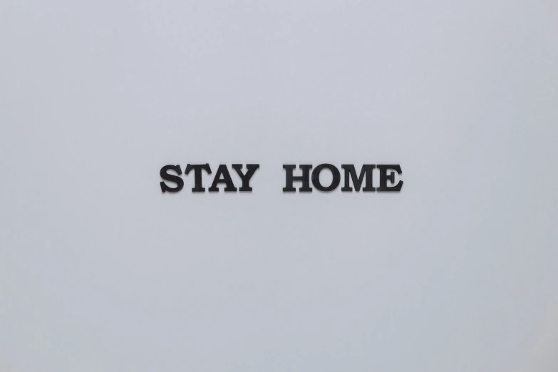 a black and white photo of a sign that says stay home, an engraving, by Ian Hamilton Finlay, flat grey background, maurizio cattelan, tiny house, very close detailed closeup