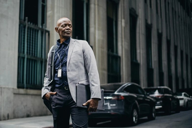 a man standing on a city street talking on a cell phone, by Dan Frazier, pexels contest winner, office clothes, gus fring, grey shift, proud looking away