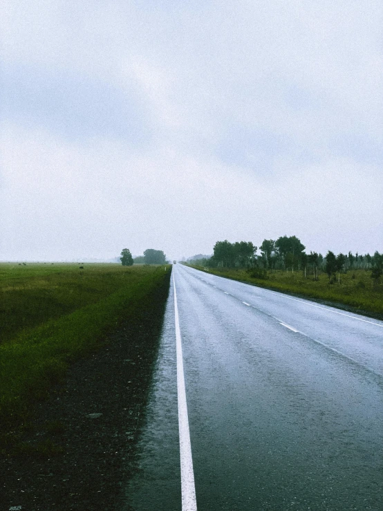 a wet road in the middle of a field, an album cover, unsplash, 1990s photograph, sydney hanson, seen from the long distance, touring