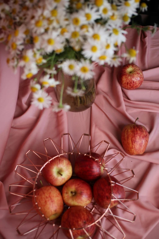 a bowl of apples and daisies on a table, shutterstock contest winner, aestheticism, soft red tone colors, red fabric, rose gold, modeled