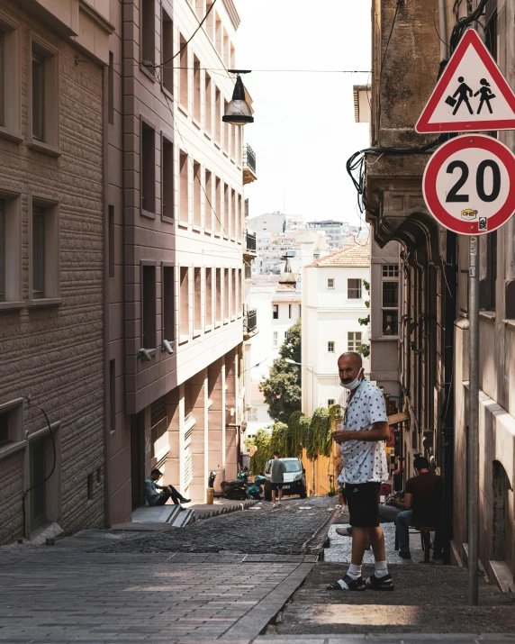 a man standing in the middle of a narrow street, traffic signs, southern european scenery, 2019 trending photo, lgbtq