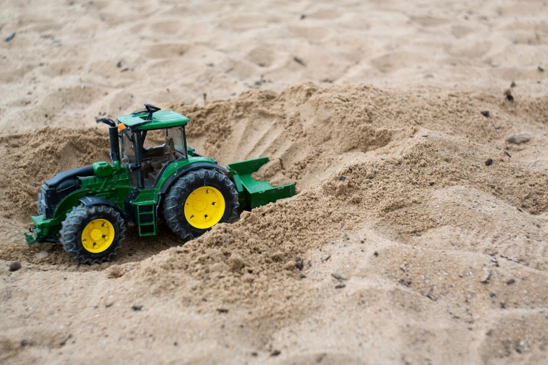 a toy tractor in the sand on a beach, by Andries Stock, unsplash, figuration libre, dynamic action shot, 15081959 21121991 01012000 4k, deep green, ilustration