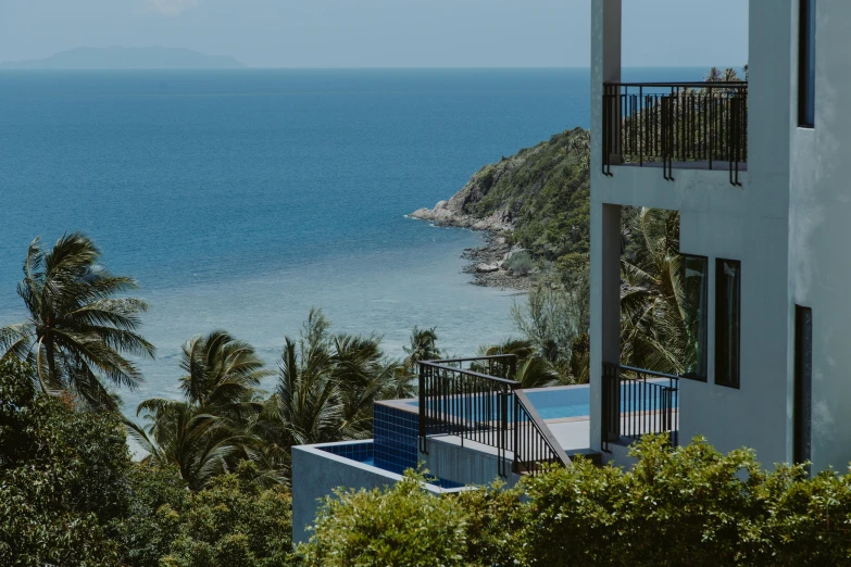 a view of the ocean from the top of a building, lush surroundings, blue and white colour scheme, thailand, staggered terraces