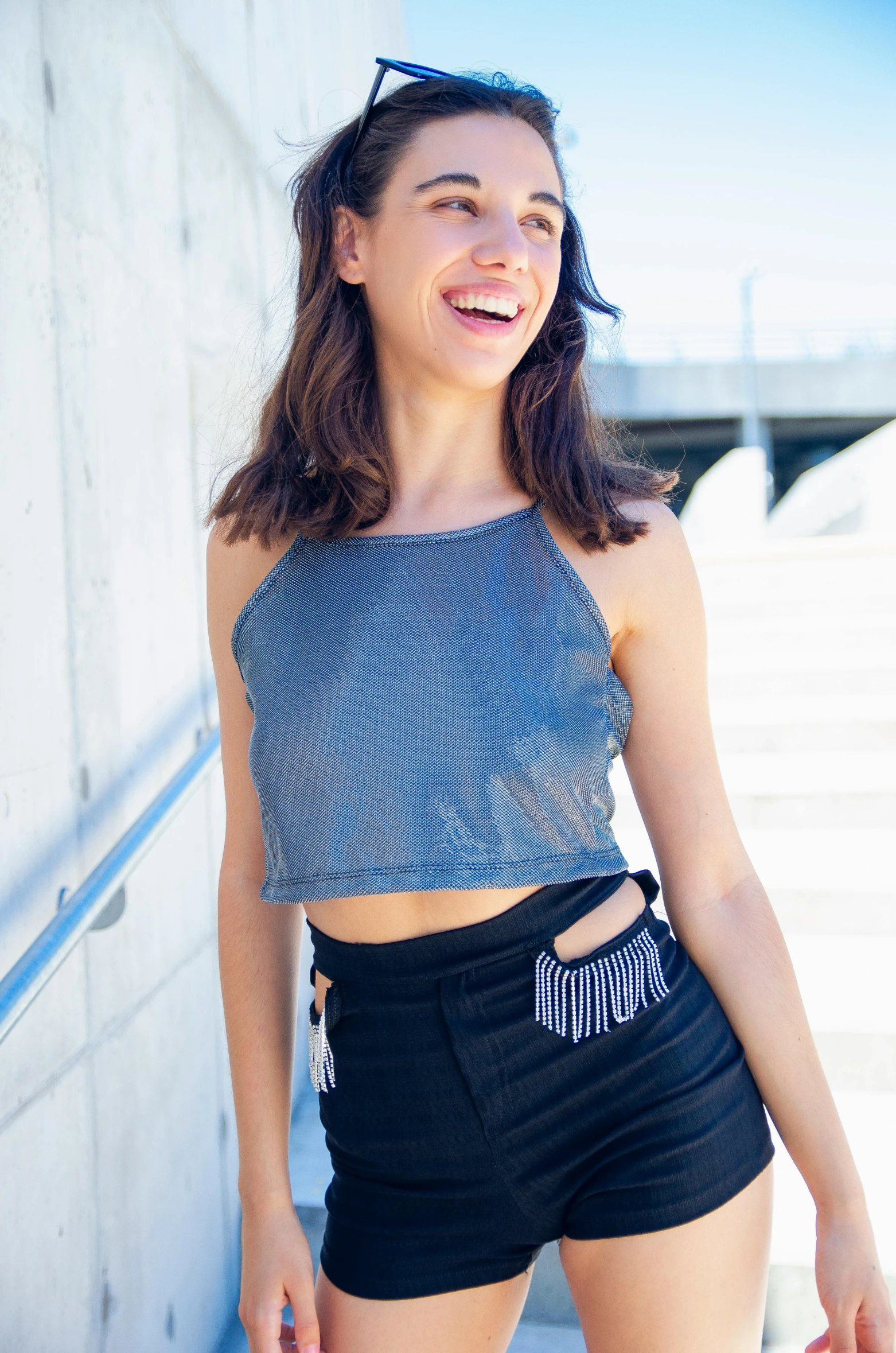 a woman standing next to a wall with a skateboard, inspired by Gina Pellón, unsplash, wearing a crop top, chainmail, smiling fashion model, wearing : tanktop