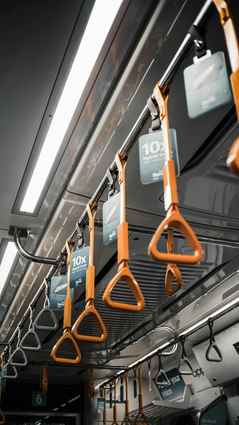 a bunch of orange handles hanging from the ceiling of a train, origin 100i, holding a crowbar, transport design, press shot