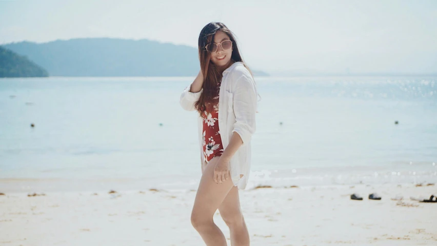 a woman standing on a beach next to the ocean, by Robbie Trevino, standing on a beach in boracay, round thighs, background image, louise zhang