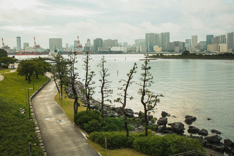 a view of a body of water with a city in the background, inspired by Tsuchida Bakusen, unsplash, shin hanga, garden road, large path, 🚿🗝📝