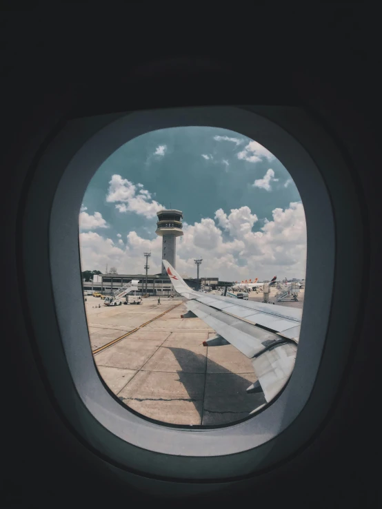 a view of an airport through an airplane window, pexels contest winner, looking up at the camera, 🚿🗝📝, vsco, on a landing pad