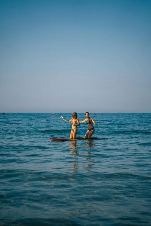 a couple of people riding on top of a surfboard in the ocean, byzantine, resort, award - winning photo ”