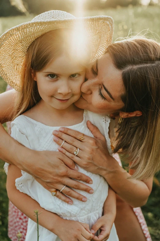 a woman kissing a little girl in a field, gold jewellery, overhead sun, portrait of women embracing, brand