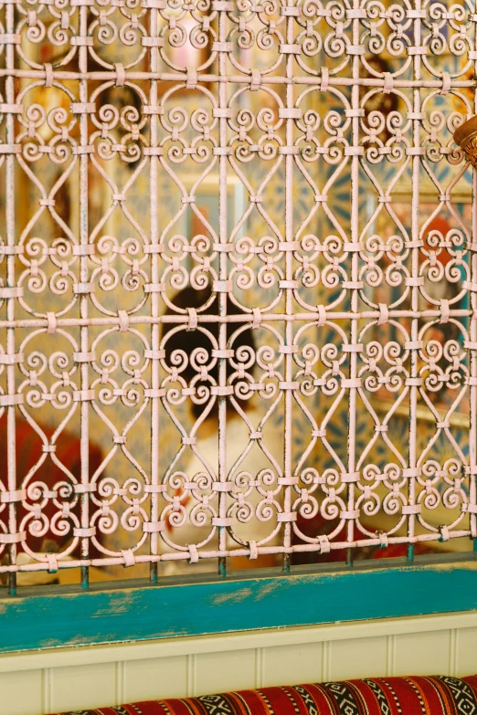 a cat sitting on a couch in front of a window, a silk screen, arabesque, iron gate, pink and gold color scheme, closeup - view, 2006 photograph