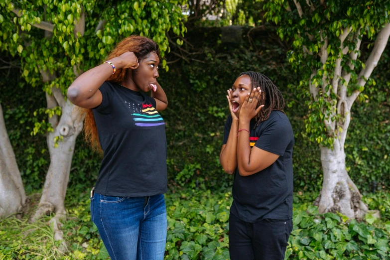 a couple of women standing next to each other, pexels contest winner, black arts movement, shouting, wearing a black tshirt, pride month, california;