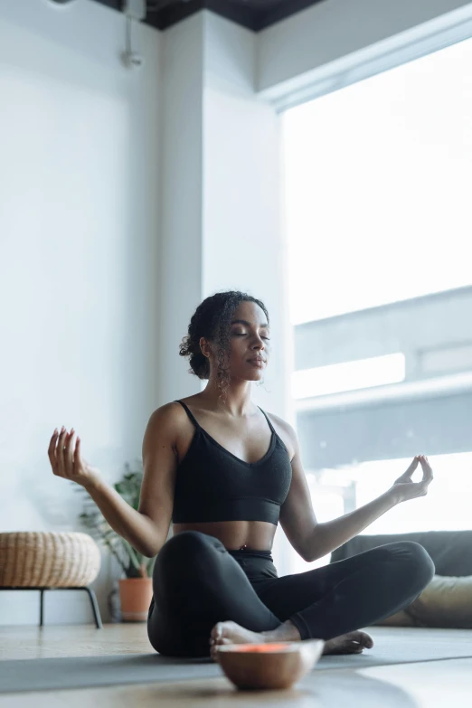 a woman sitting on the floor doing yoga, by Carey Morris, pexels contest winner, sitting on a couch, hear no evil, in a gym, essence