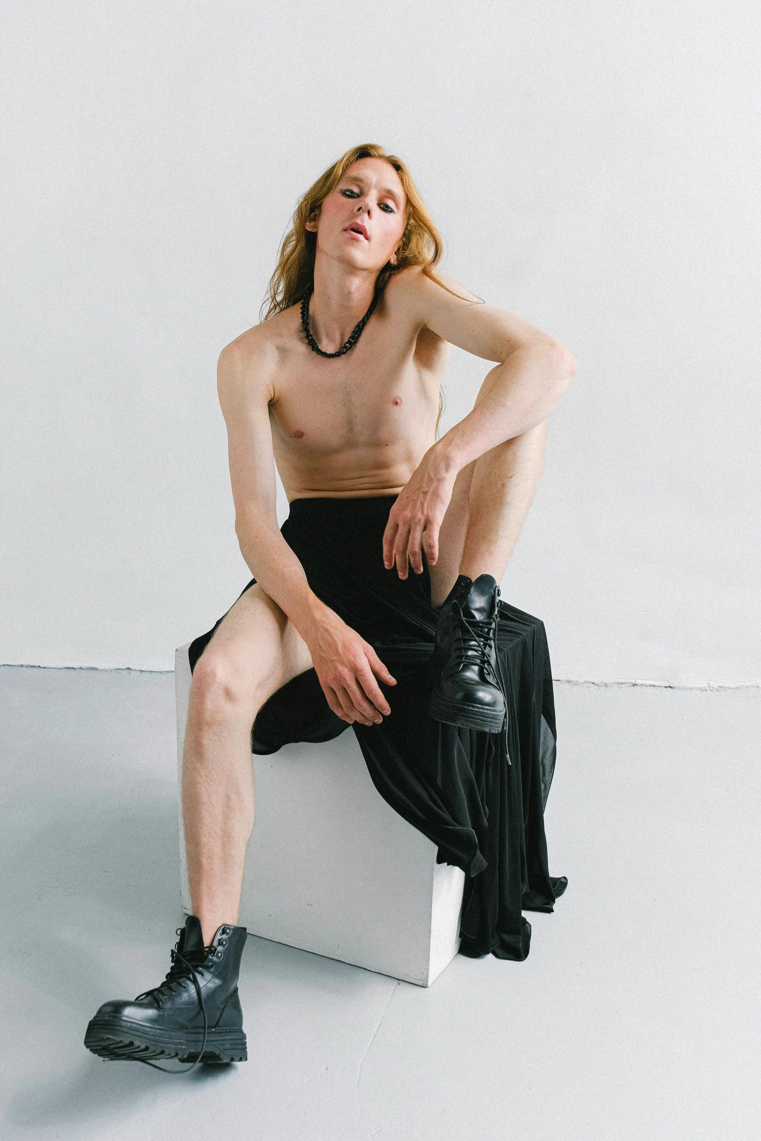 a shirtless man sitting on top of a white box, an album cover, inspired by Nan Goldin, renaissance, joe biden as a transgender woman, jamie campbell bower, lois greenfield, uncropped