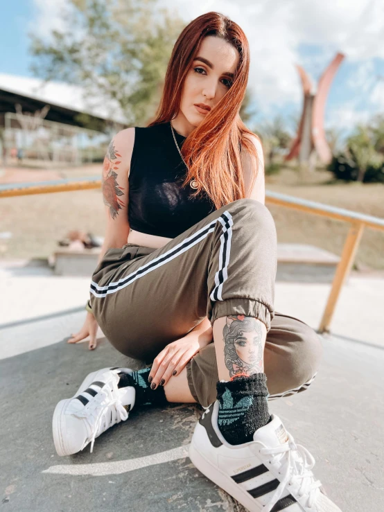 a woman with red hair sitting on a skateboard, a colorized photo, inspired by Mary Jane Begin, trending on pexels, wearing adidas clothing, wearing cargo pants, wearing shipibo tattoos, better known as amouranth