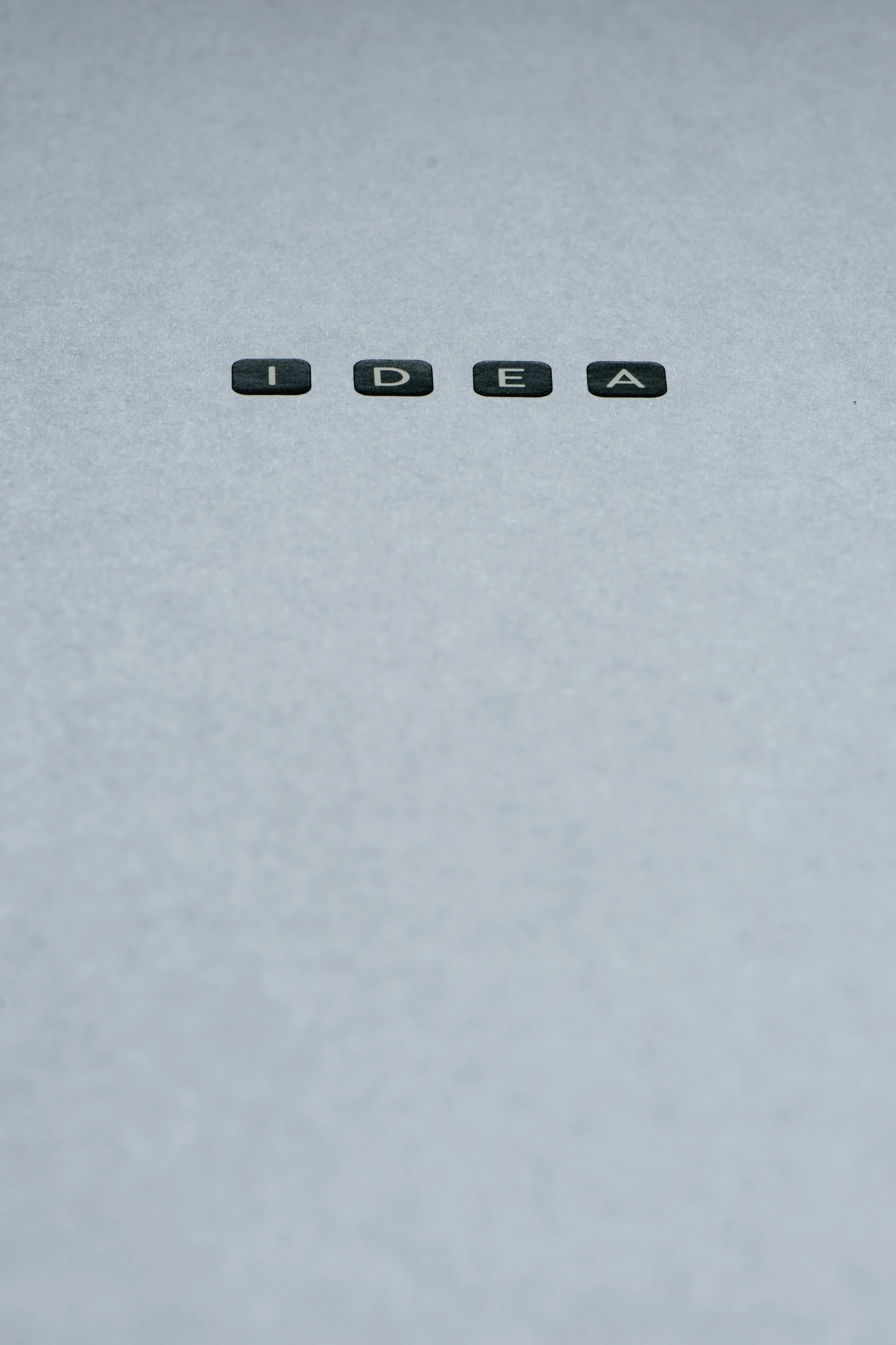 the word igua spelled in black letters on a white surface, an album cover, by Adam Rex, unsplash, conceptual art, lightbulb, grey, blank paper, 15081959 21121991 01012000 4k