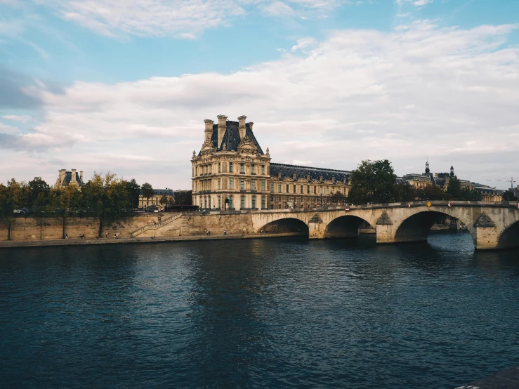 a bridge over a river with a building in the background, pexels contest winner, paris school, vsco, pointed arches, lakeside, datapipeline or river