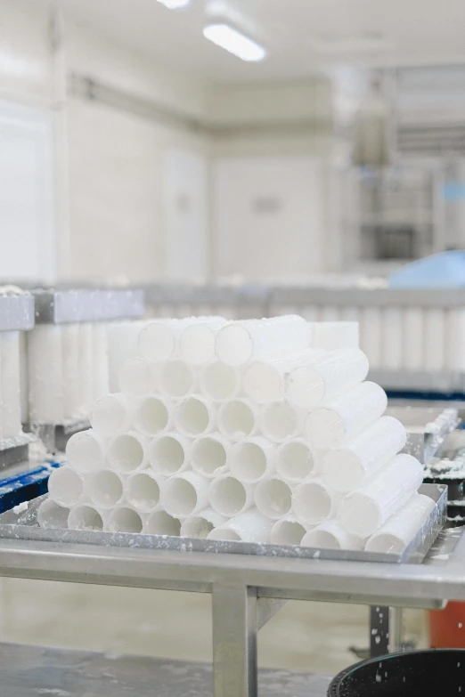 a man working on a machine in a factory, inspired by Rachel Whiteread, unsplash, lots of mozzarella balls, o'neill cylinder colony, white plastic, tubes