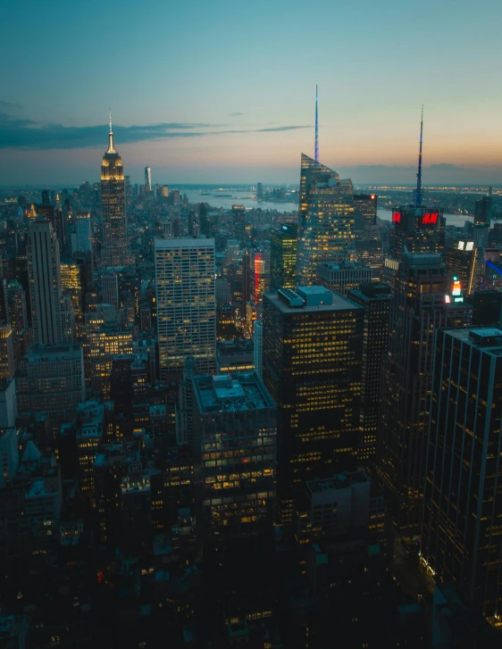 a view of a city from the top of a building, in the evening