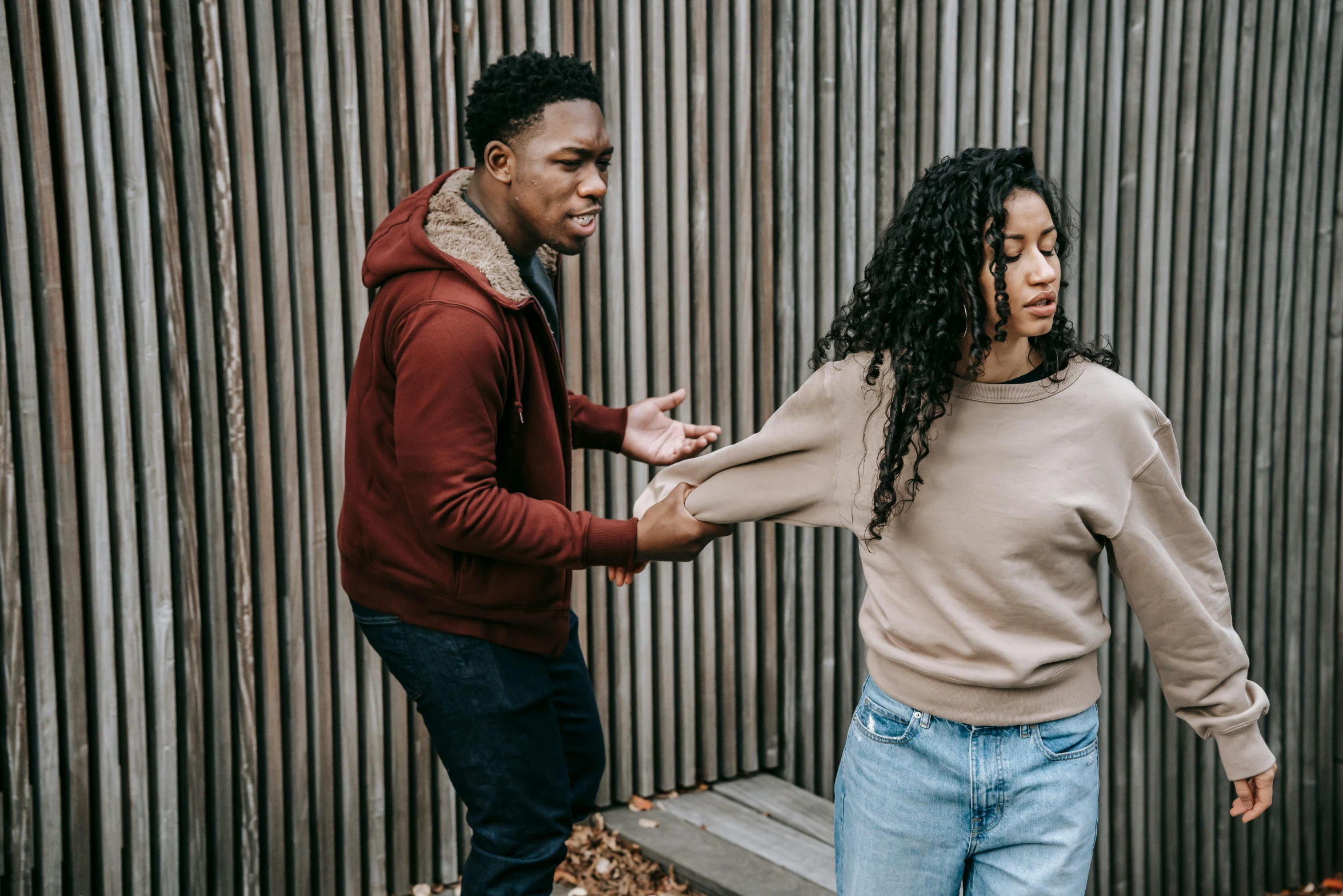 a man and a woman standing next to each other, trending on pexels, happening, fistfight, brown clothes, teenage girl, coloured photo