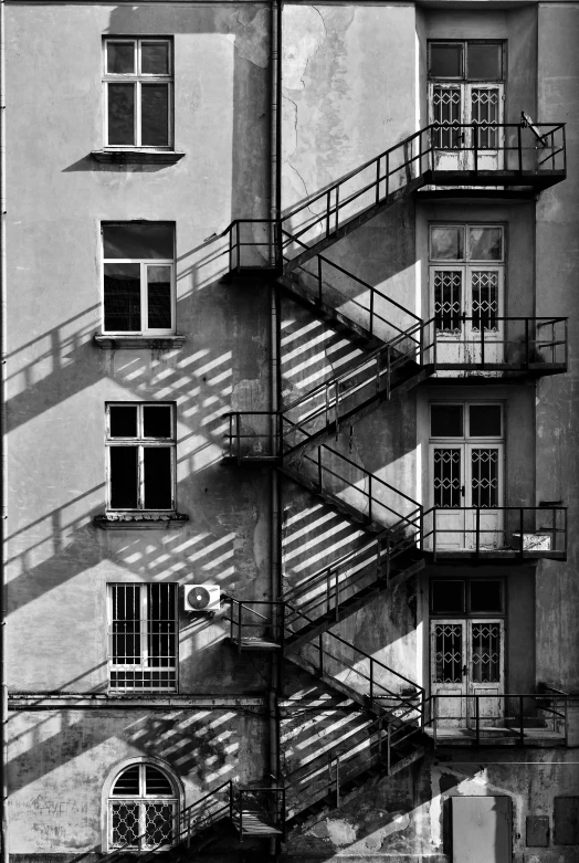 a black and white photo of a building with stairs, inspired by André Kertész, backlit!!, in legnica, buildings photorealism, square lines