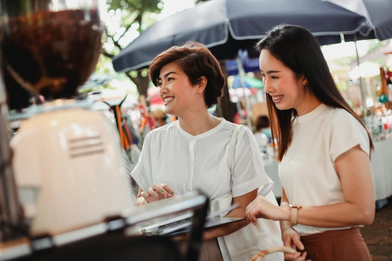 a couple of women standing next to each other, trending on unsplash, market stalls, avatar image, aussie baristas, bangkok townsquare