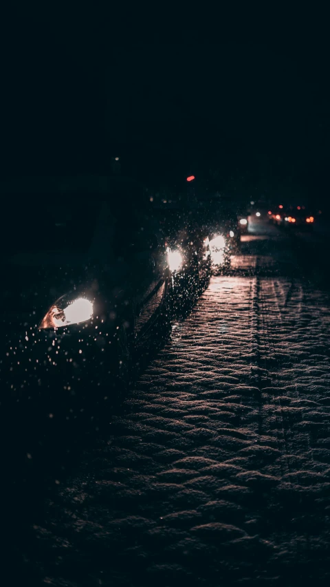 a group of cars driving down a street at night, an album cover, inspired by Elsa Bleda, unsplash contest winner, snowstorm ::5, wet asphalt, grainy. poorly rated, glowing crystals on the ground