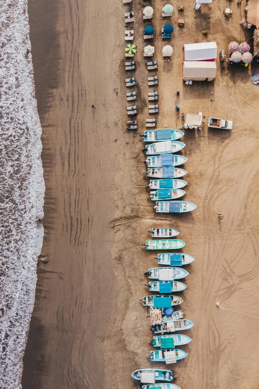 a group of boats sitting on top of a sandy beach, by Daniel Lieske, pexels contest winner, airplane view, oman, fish market, chile